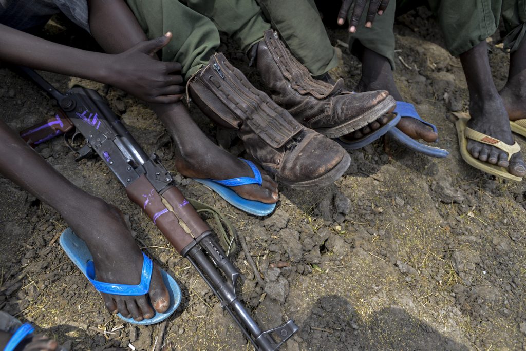 Children sit together while undergoing release from the SSDA Cobra Faction armed group, in Pibor, Jonglei State. An assault rifle lies between the feet of one of the children. On 10 February 2015 in South Sudan, UNICEF and partners oversaw the release of 300 children from the South Sudan Democratic Army (SSDA) Cobra Faction armed group, in Pibor, Jonglei State. The children surrendered their weapons and uniforms in a UNICEF-supported ceremony overseen by the South Sudan National Disarmament, Demobilization and Reintegration Commission and the Cobra Faction. They will spend their first night in an interim care centre, where they will be provided with food, water and clothing ñ and will also have access to health and psychosocial services. Their release follows that of an additional 249 children from Cobra Faction on 27 January, in the village of Gumuruk, Jonglei State. Since that time, 179 of the children have returned home to their families, while 70 children continue to live at the UNICEF-supported interim care centre as family tracing and reunification is carried out. All 249 boys attend the centre every day for meals, recreational activities and psychosocial support. Estimating that the cost for the release and reintegration of each child is approximately US$2,330 for 24 months, UNICEF is appealing for $13 million to fund the immediate needs of the released children and the vulnerable communities where they live. The children released on 27 January and 10 February are among approximately 3,000 in the Cobra Faction whose release has been secured by UNICEF and partners ñ in one of the largest ever such releases of children associated with armed groups or forces. The releases will continue in phases over the coming month. The released children and local communities have overwhelmingly told UNICEF that education is their number one priority. UNICEF is improving access to education in each of the release locations by either strengthening existing facilities or pr